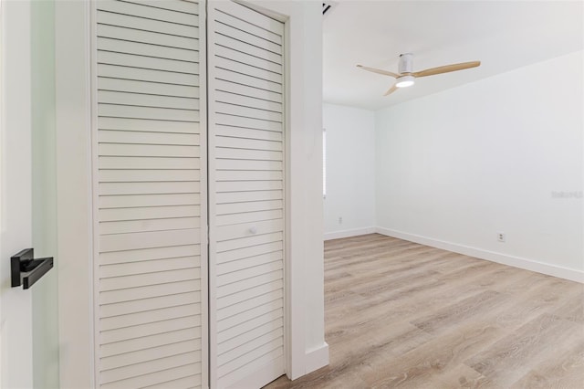 unfurnished bedroom featuring baseboards, wood finished floors, and a closet