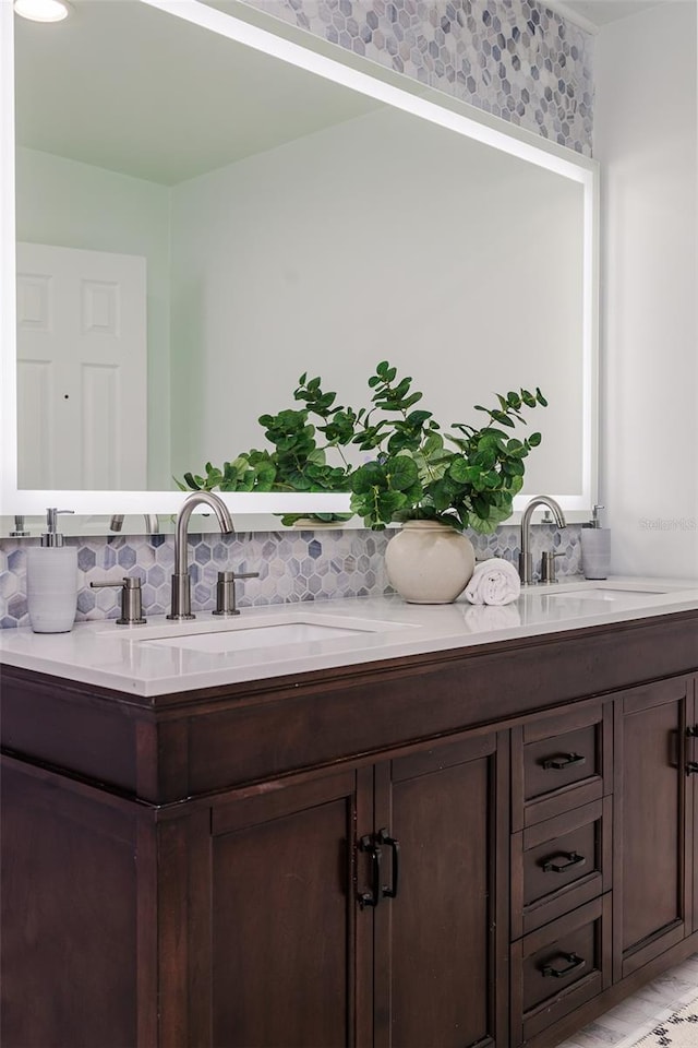 full bath with double vanity, a sink, and backsplash