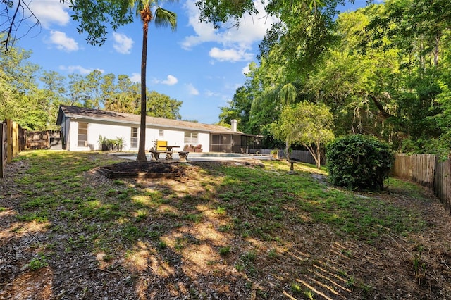 view of yard with a sunroom, a fenced backyard, and a patio
