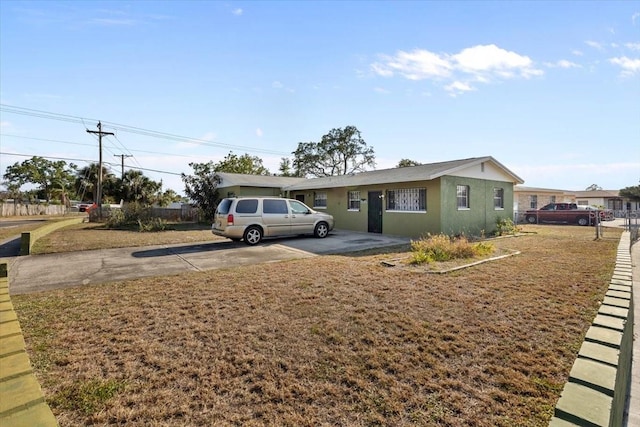 view of front of house featuring driveway, a front yard, and stucco siding