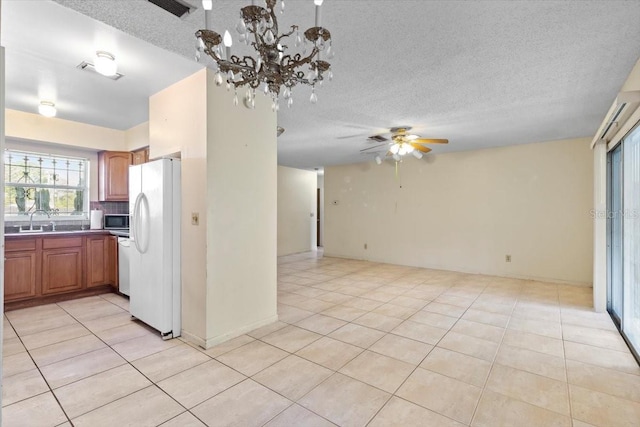 kitchen featuring a ceiling fan, white refrigerator with ice dispenser, a sink, light tile patterned floors, and open floor plan