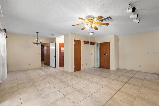 empty room with visible vents, a textured ceiling, ceiling fan with notable chandelier, and light tile patterned floors