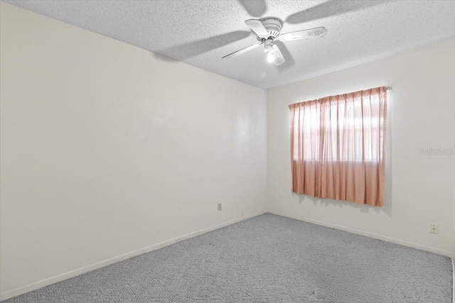 carpeted empty room featuring a ceiling fan, a textured ceiling, and baseboards