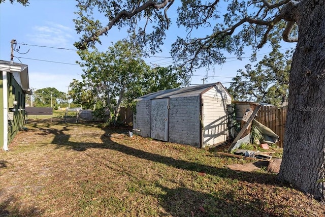view of yard featuring a storage shed, an outdoor structure, and a fenced backyard