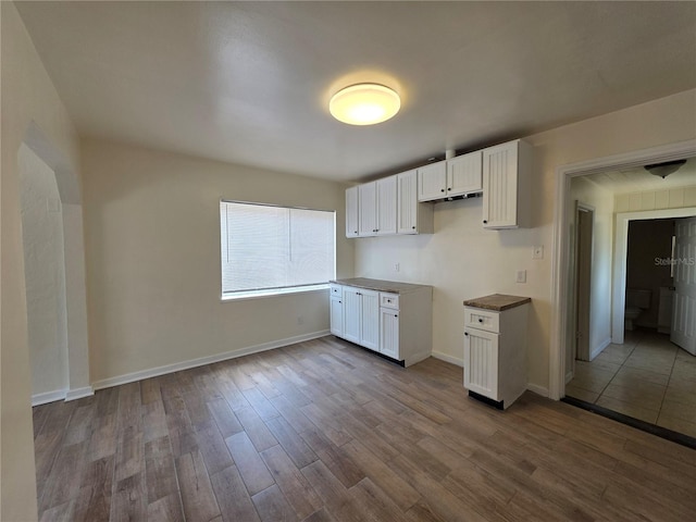 718 Paris Ave S, Saint Petersburg, FL 33701 - kitchen featuring dark countertops, baseboards, white cabinetry, and dark wood-type flooring