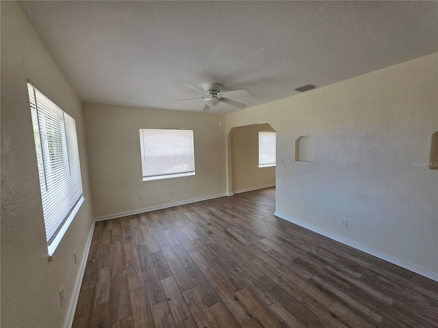 718 Paris Ave S, Saint Petersburg, FL 33701 - unfurnished room with a ceiling fan, arched walkways, visible vents, and dark wood-style floors