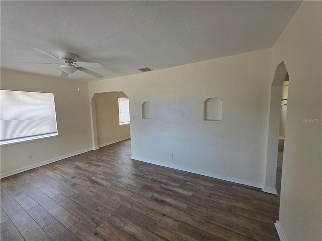 718 Paris Ave S, Saint Petersburg, FL 33701 - spare room featuring a ceiling fan, visible vents, arched walkways, dark wood finished floors, and baseboards