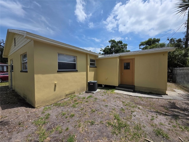718 Paris Ave S, Saint Petersburg, FL 33701 - rear view of property featuring central AC, stucco siding, and fence