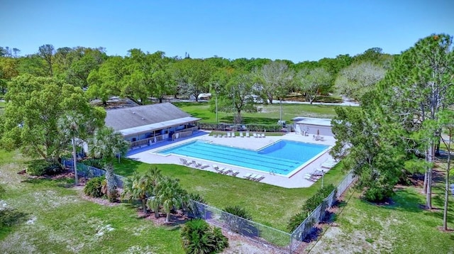 community pool with fence and a yard