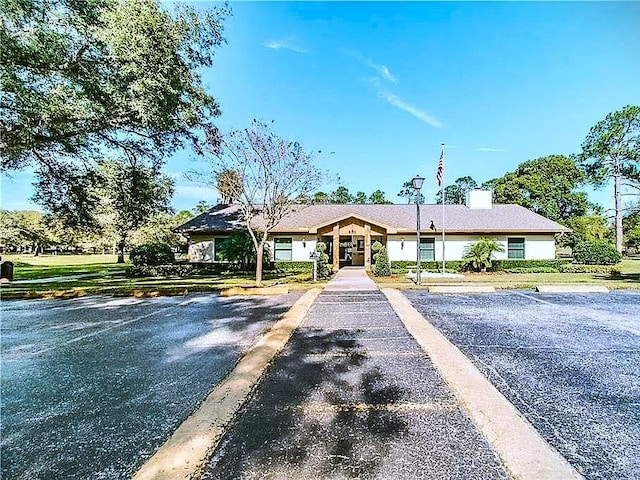 view of front of property with uncovered parking and a chimney