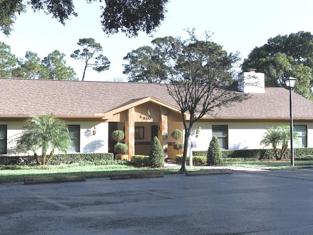 single story home featuring a chimney