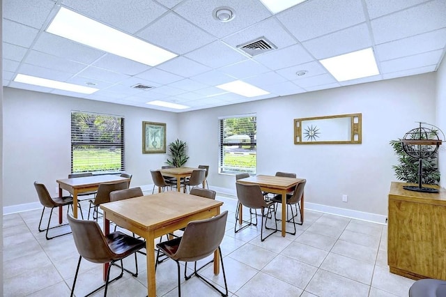 dining space with light tile patterned floors, visible vents, and a paneled ceiling