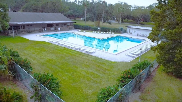 community pool with fence, a yard, and a patio area