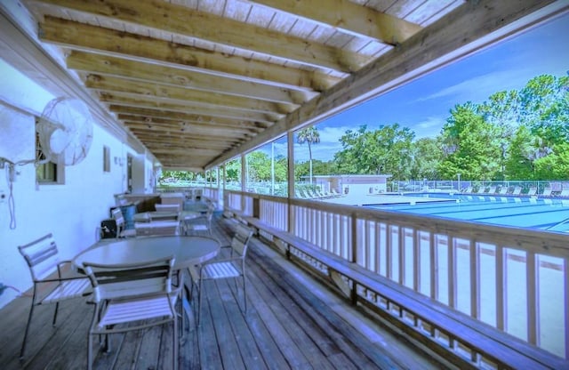 deck with a community pool and outdoor dining space