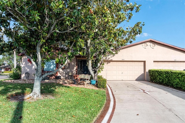 view of front of property featuring a garage, driveway, a front lawn, and stucco siding