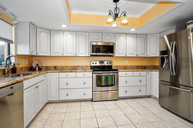 kitchen featuring pendant lighting, a sink, stone countertops, ornamental molding, and stainless steel appliances