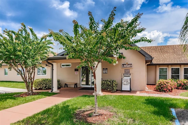 ranch-style house with a front lawn and stucco siding