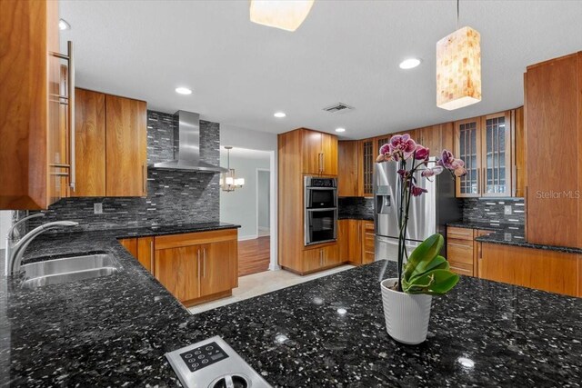 4531 44th St S, Saint Petersburg, FL 33711 - kitchen featuring wall chimney range hood, visible vents, brown cabinets, a sink, and stainless steel appliances