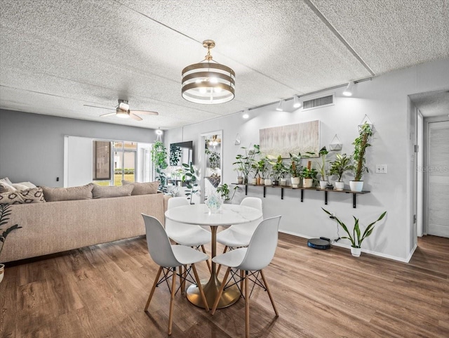 dining area featuring a ceiling fan, visible vents, track lighting, and wood finished floors