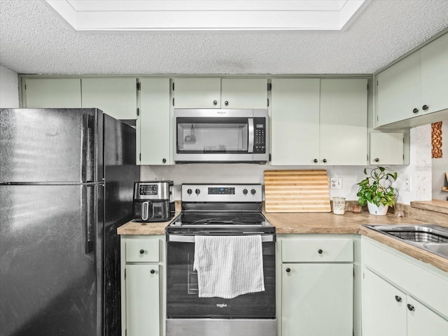 kitchen with light countertops, a textured ceiling, and appliances with stainless steel finishes