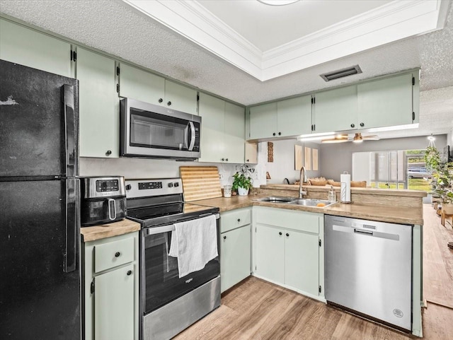 kitchen with visible vents, crown molding, light wood-style floors, a sink, and stainless steel appliances