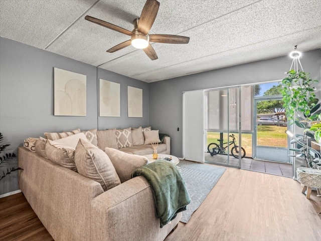 living room featuring a ceiling fan, a textured ceiling, and wood finished floors