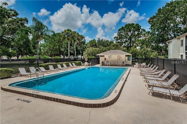community pool featuring fence and a patio area
