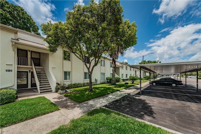 exterior space with a residential view, covered and uncovered parking, and stairway