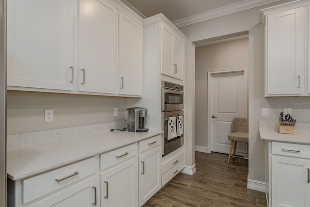 21590 Violet Periwinkle Dr, Land O Lakes, FL 34637 - kitchen featuring ornamental molding, baseboards, stainless steel double oven, white cabinets, and dark wood finished floors