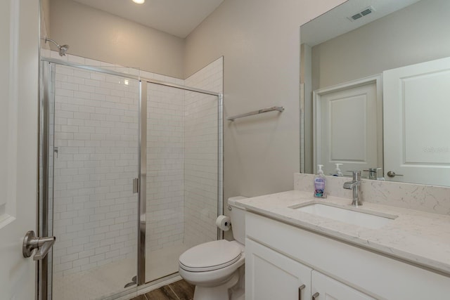 21590 Violet Periwinkle Dr, Land O Lakes, FL 34637 - full bath featuring vanity, toilet, a shower stall, wood finished floors, and visible vents