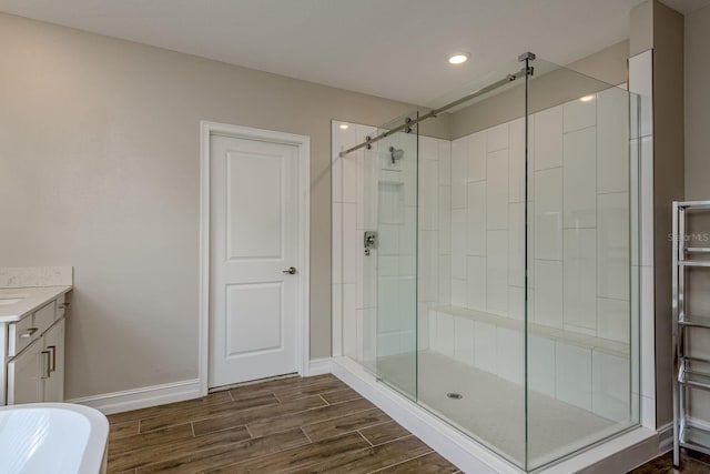 21590 Violet Periwinkle Dr, Land O Lakes, FL 34637 - bathroom featuring vanity, a freestanding tub, wood finished floors, baseboards, and a stall shower