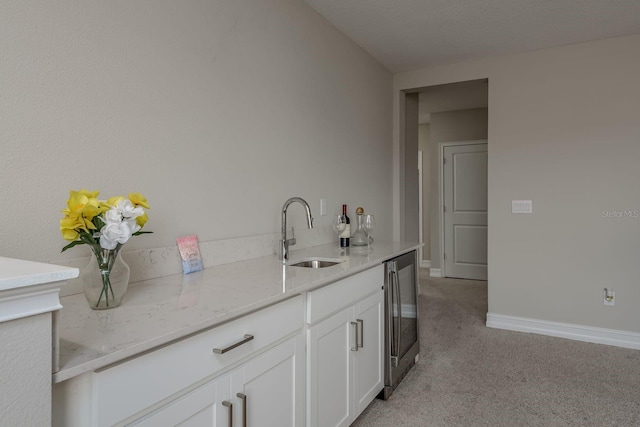 21590 Violet Periwinkle Dr, Land O Lakes, FL 34637 - interior space featuring white cabinets, light stone countertops, light colored carpet, a sink, and baseboards
