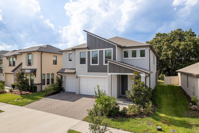 21590 Violet Periwinkle Dr, Land O Lakes, FL 34637 - modern home with a garage, a front lawn, decorative driveway, stucco siding, and board and batten siding