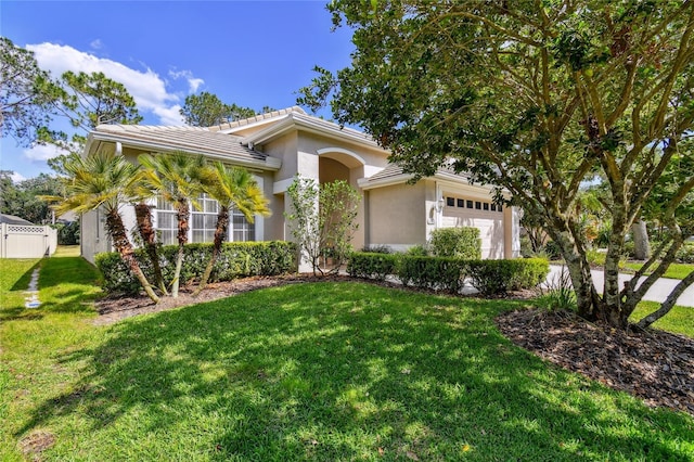 mediterranean / spanish-style home featuring a front lawn, a tiled roof, stucco siding, and a garage