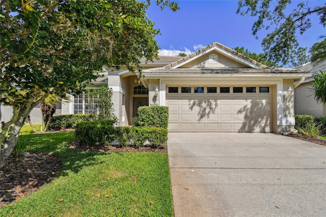 single story home featuring an attached garage, stucco siding, a tile roof, concrete driveway, and a front lawn
