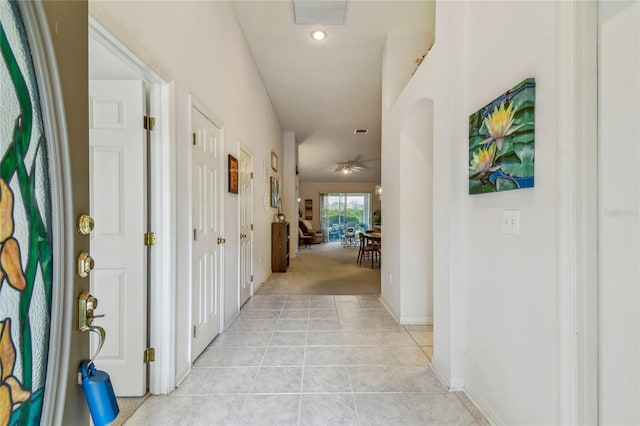 hall with recessed lighting, light tile patterned floors, baseboards, visible vents, and light colored carpet