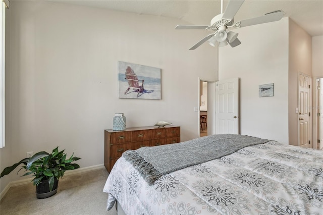 bedroom with baseboards, carpet flooring, a high ceiling, and a ceiling fan