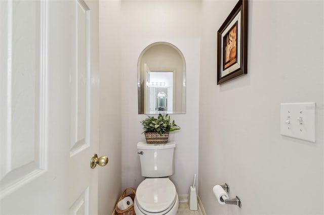 half bathroom with toilet and baseboards