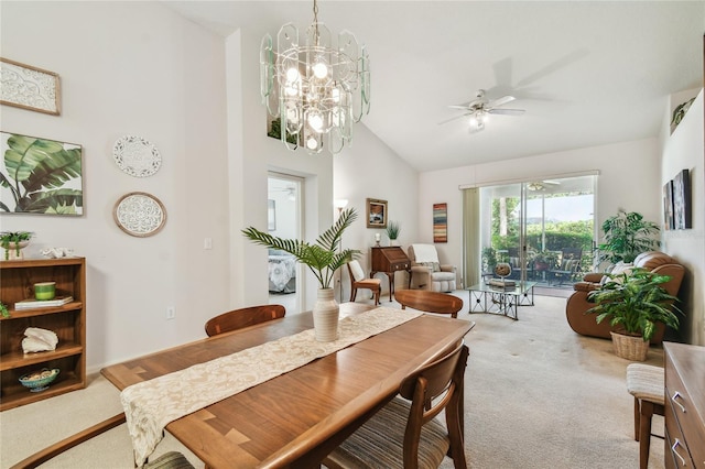 dining area featuring high vaulted ceiling, carpet, and ceiling fan with notable chandelier