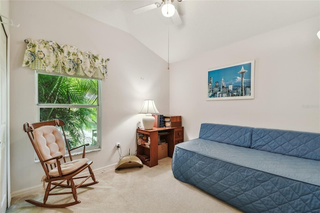 sitting room with vaulted ceiling, light carpet, baseboards, and a ceiling fan