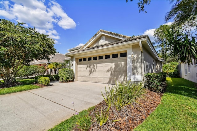 view of front of house featuring an attached garage, stucco siding, driveway, and a front yard
