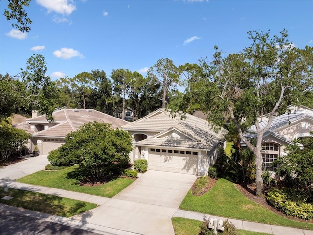view of front facade with concrete driveway, a front lawn, a tiled roof, and a garage
