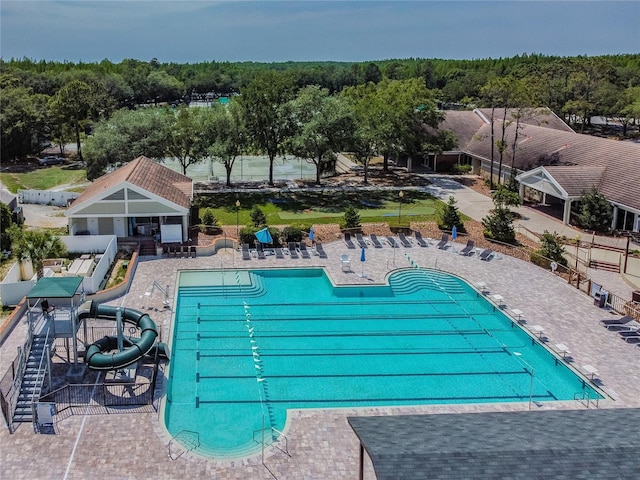 pool featuring a patio, a water slide, and fence