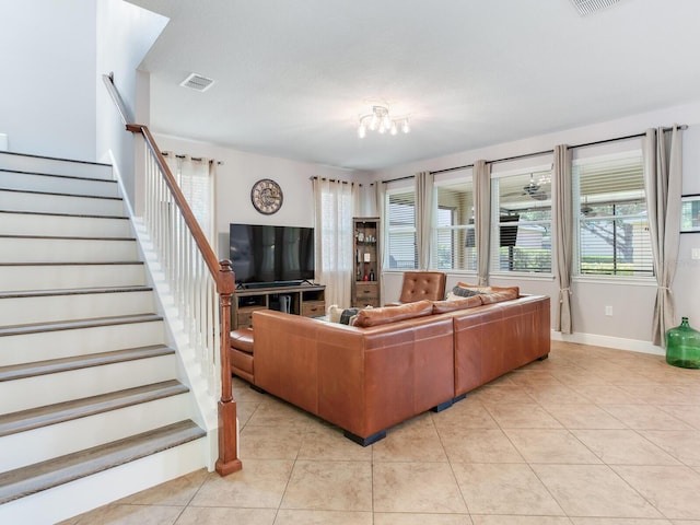 living area featuring visible vents, baseboards, stairs, and light tile patterned floors