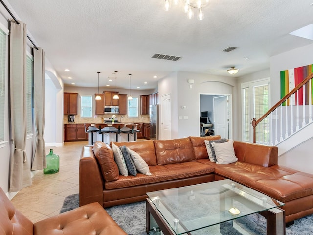 living area with visible vents, a healthy amount of sunlight, and light tile patterned floors