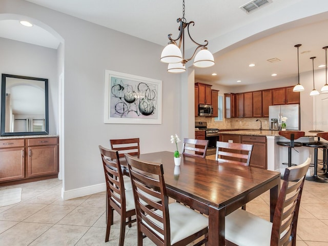 dining space featuring visible vents, arched walkways, light tile patterned floors, baseboards, and recessed lighting