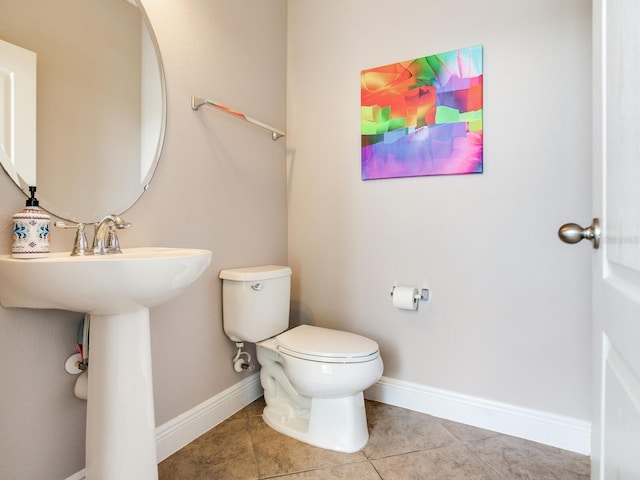 half bath featuring toilet, tile patterned floors, and baseboards