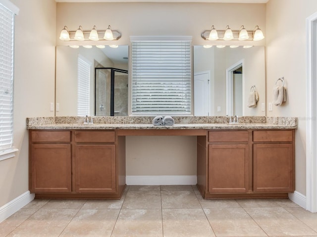 bathroom featuring baseboards, two vanities, and a shower stall
