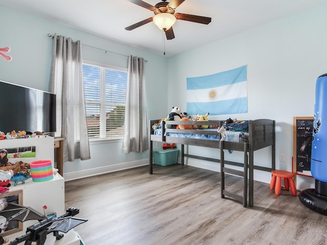 bedroom featuring baseboards, a ceiling fan, and wood finished floors