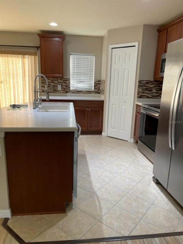 2950 Willowleaf Ln, Wesley Chapel, FL 33544 - kitchen with a sink, a kitchen island with sink, light countertops, stainless steel appliances, and backsplash